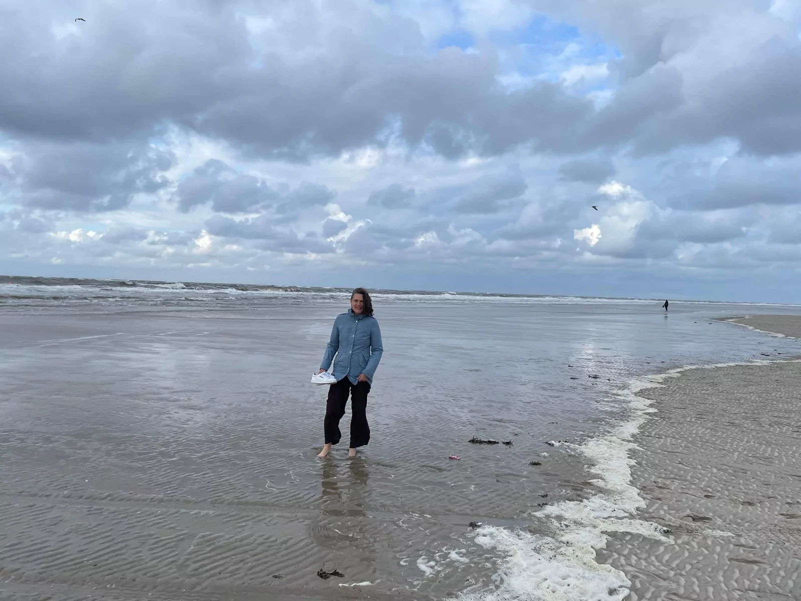 Barfuß am Nordseestrand von Spiekeroog: Ich genieße die Weite des Watts bei bewölktem Himmel.